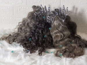 Opulent gray curly hair bundles displayed with clips on a soft white background
