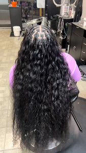 Long flowing raw Indian curly hair bundles installed with cornrow braids for a stylish look