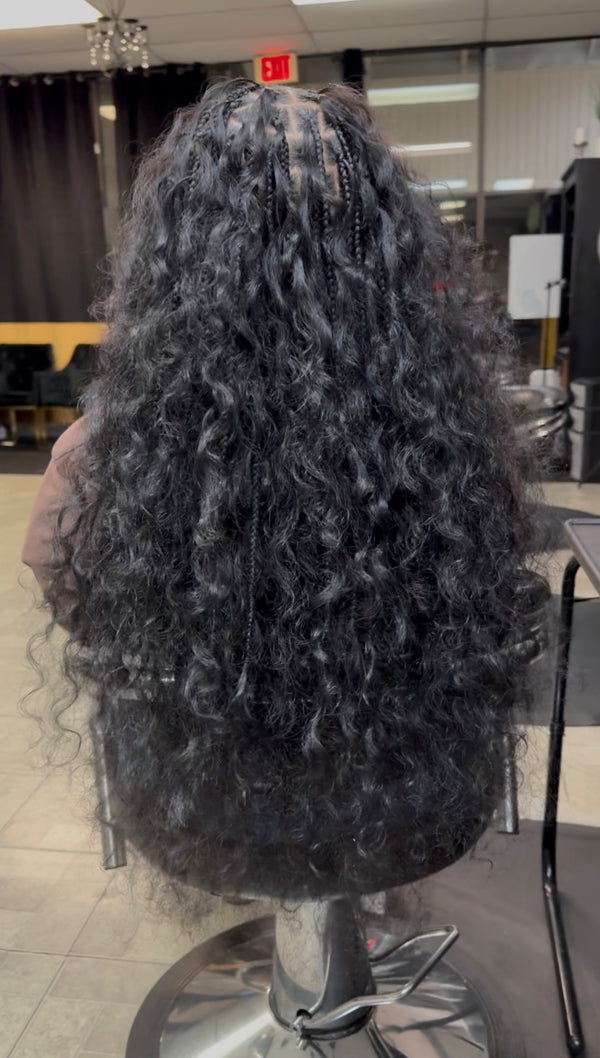Long black raw Indian curly hair bundles styled for a natural look in a salon setting