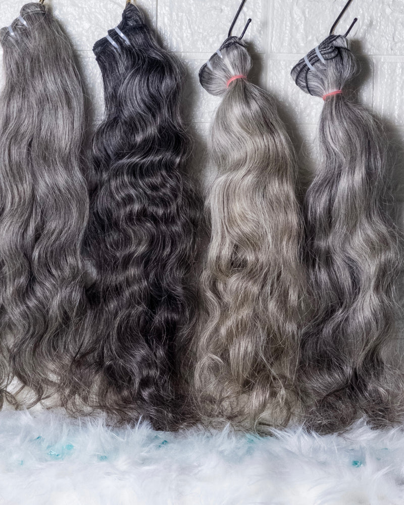 Four bundles of Raw wavy Indian hair in various shades showcasing natural wave patterns